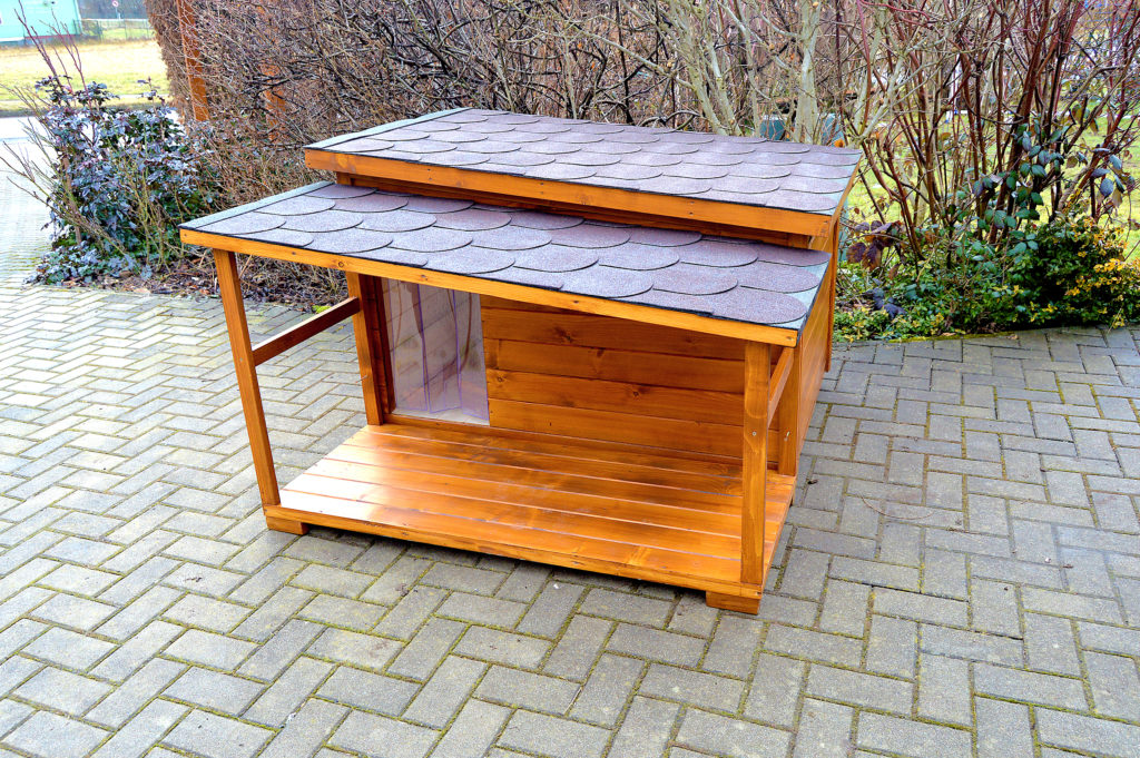 Psia búda DINO so šikmou strechou a praktickou krytou terasou vo svetlohnedom odtieni dub, s červenohnedou krytinou a vchodom prekrytým tepelnou clonou #1