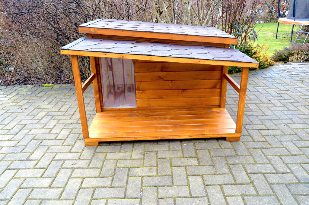 Psia búda DINO so šikmou strechou a praktickou krytou terasou vo svetlohnedom odtieni dub, s červenohnedou krytinou a vchodom prekrytým tepelnou clonou #2